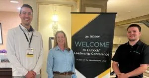 Hunter Wells, Jolene Meese and Caleb Summers, staff members at Snyder Manufacturing, pose next to the ATA Outlook Leadership Conference welcome sign.